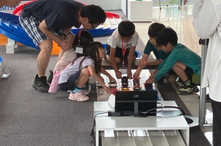 親子でミニ四駆サーキットを楽しんでいる画像