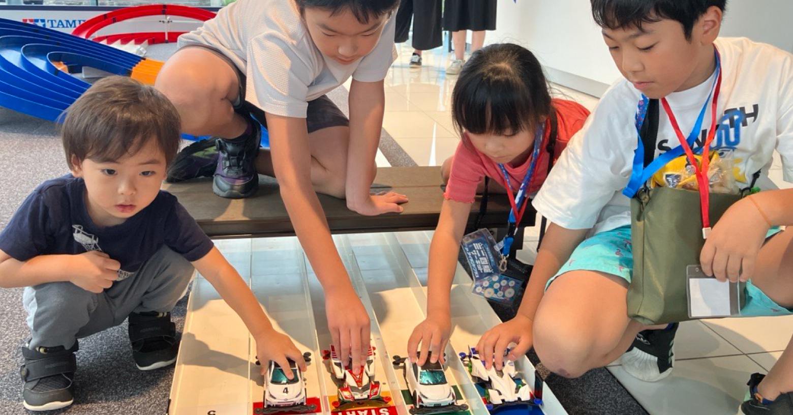 ミニ四駆サーキットで遊ぶ子供たちの画像