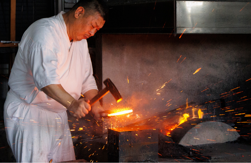 熱した玉鋼を打ちつけて平たく延ばす工程の画像